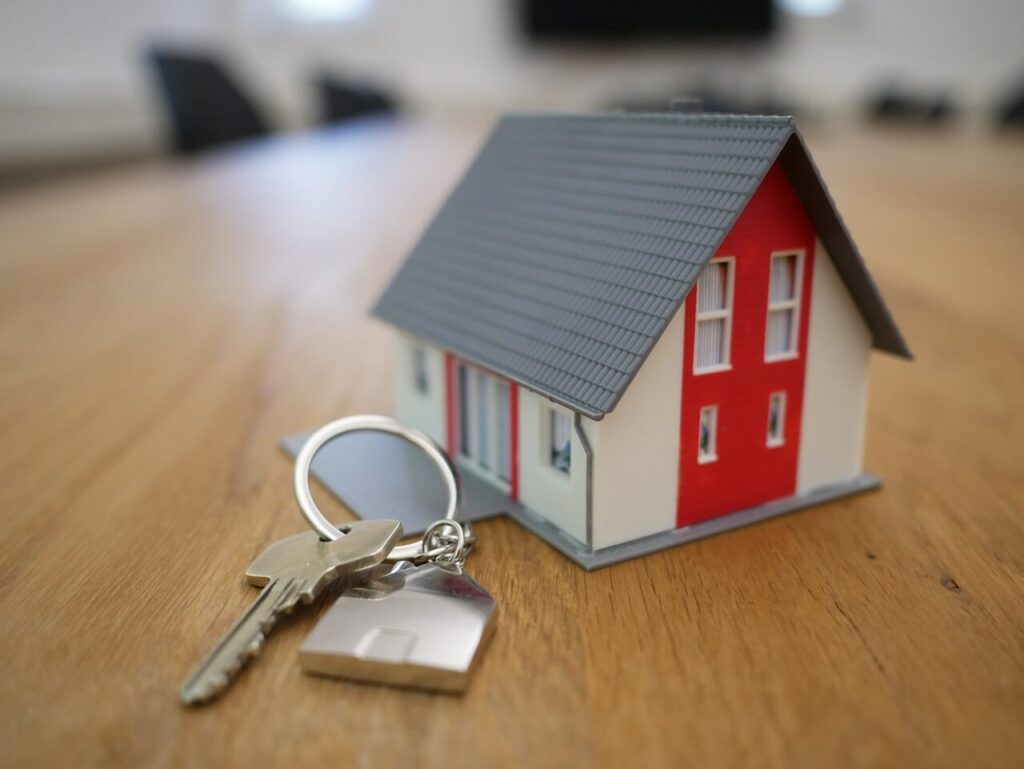 Small house model with keys on a table representing rental housing